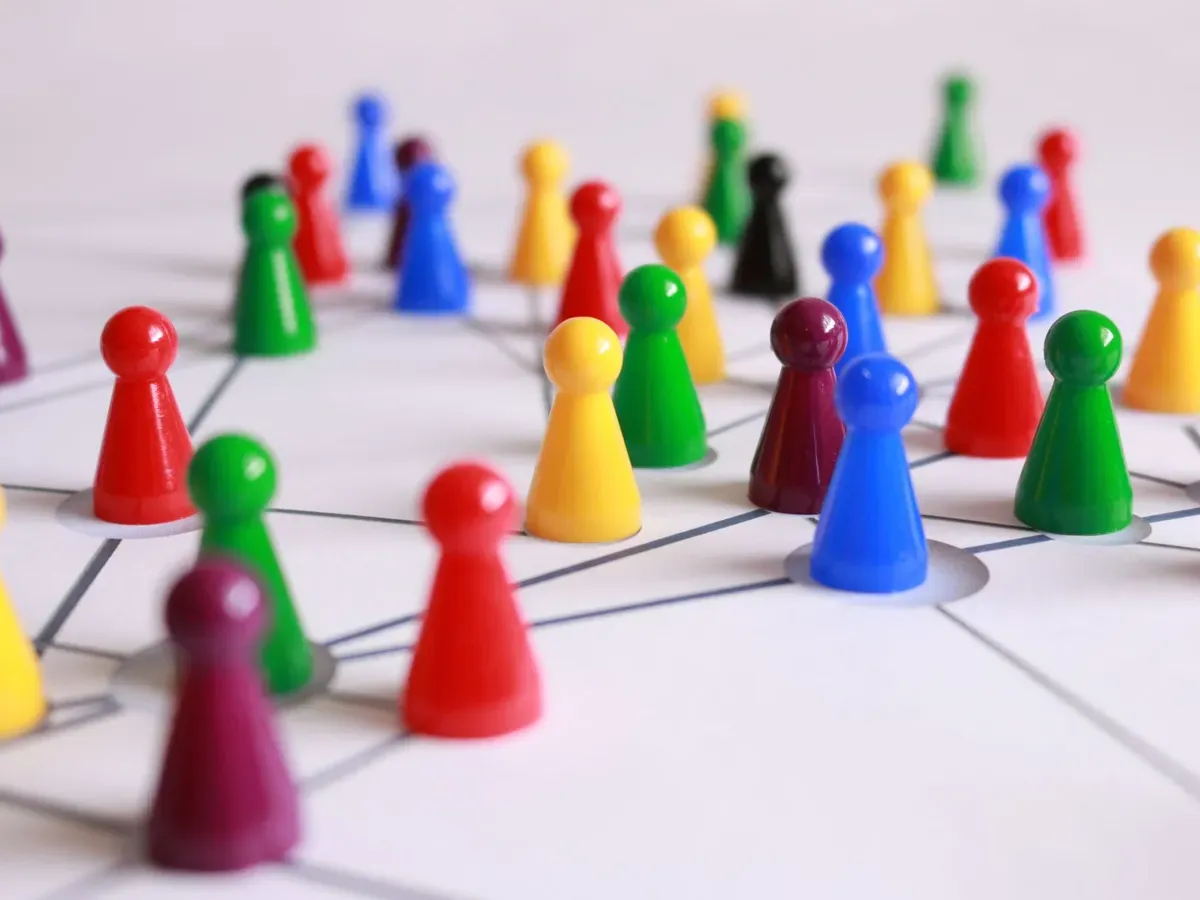 Colourful wooden game pawns on a board — play pieces, not cash